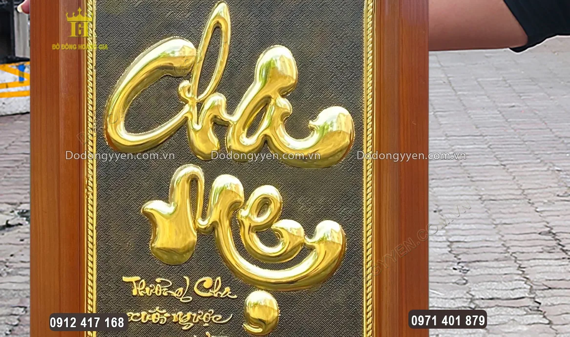 Chữ cha mẹ được chạm th&uacute;c nổi theo kiểu chữ thư ph&aacute;p ở trung t&acirc;m bức tranh